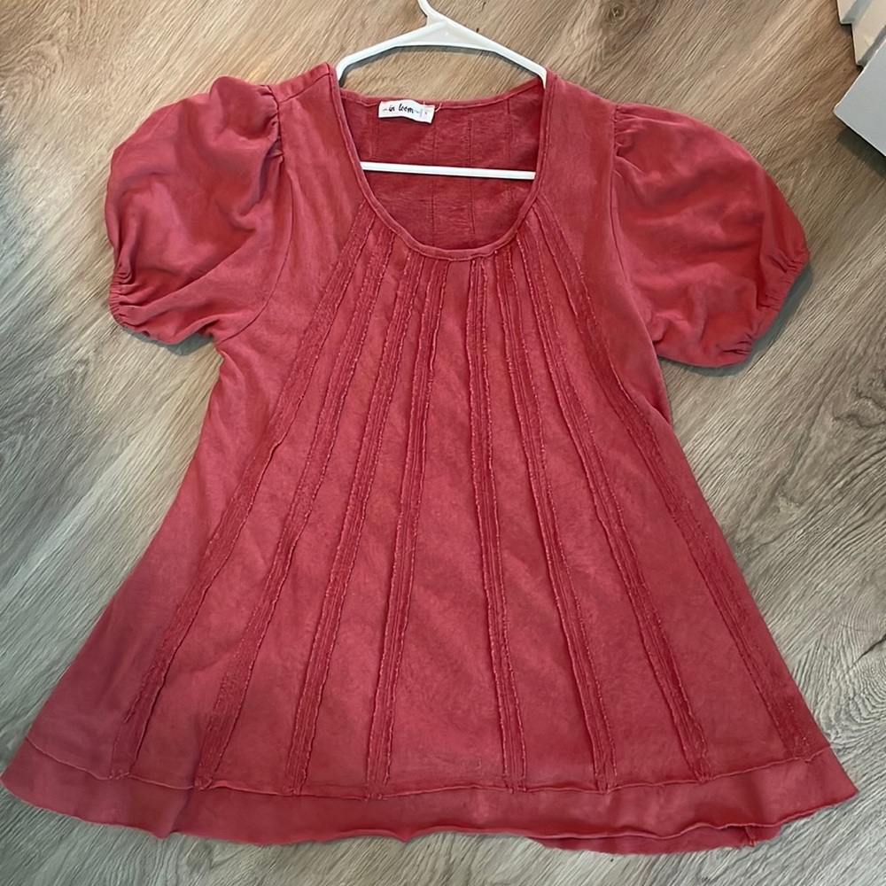 Size small. Burnt orange red color. Puff sleeves. Pretty fabric line detailing.
